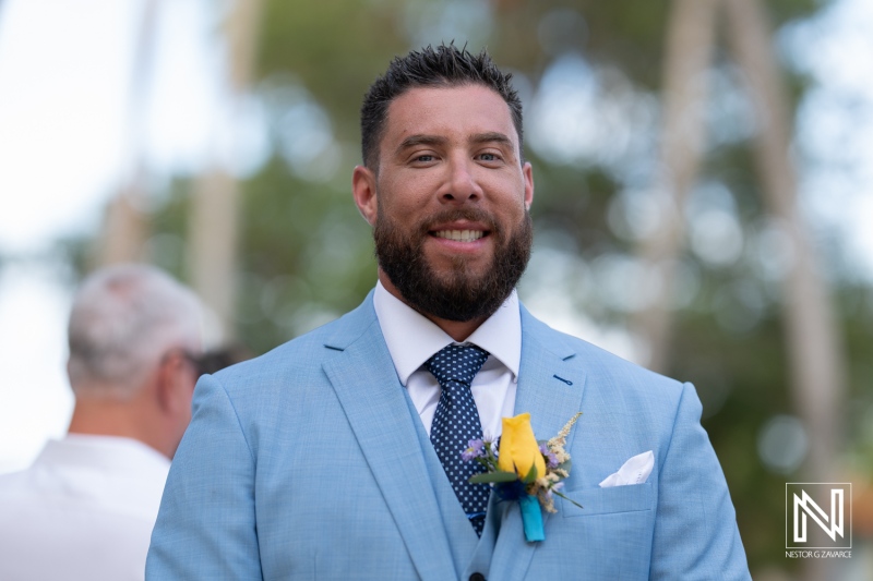 Groom smiles warmly at his wedding ceremony at Sunscape Curacao Resort surrounded by tropical beauty