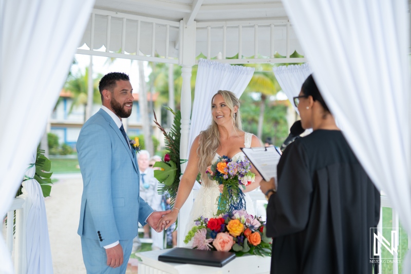 Couple exchange vows at a beautiful wedding ceremony in Curacao at Sunscape Curaçao Resort during bright sunny weather