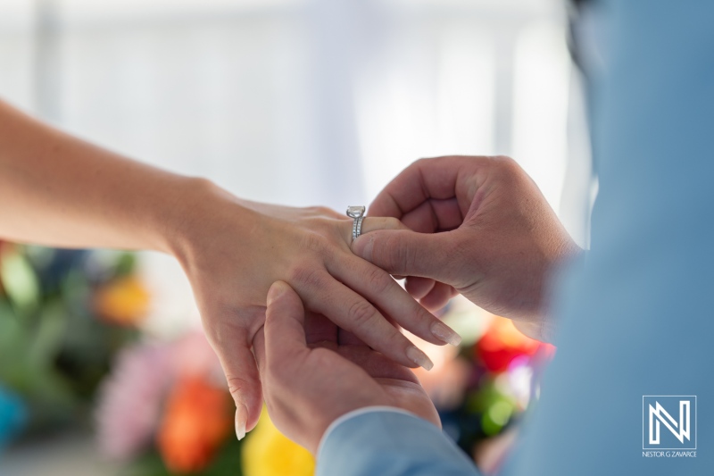 Couple exchanges wedding vows at Sunscape Curacao Resort surrounded by vibrant flowers and tropical scenery