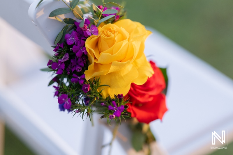 Colorful floral arrangement adorns a chair at a wedding ceremony in Sunscape Curacao Resort during sunset