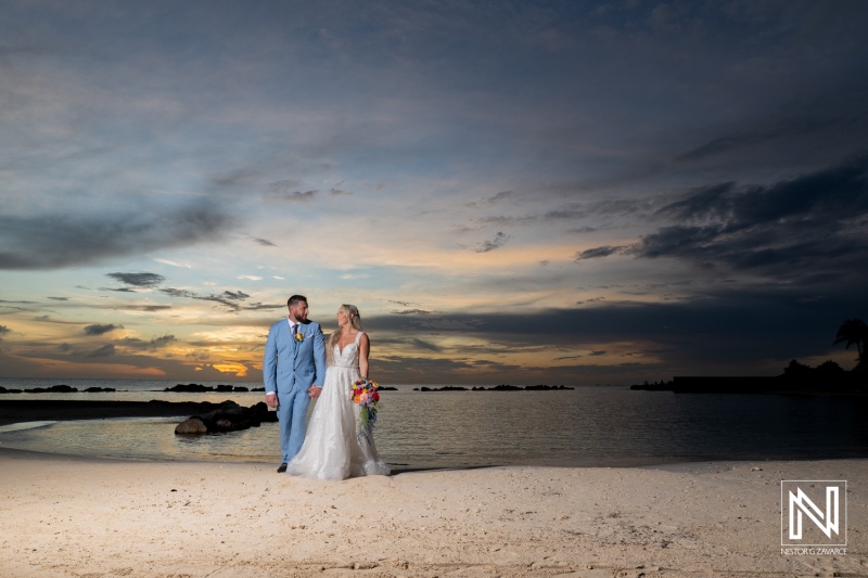 Couple enjoys a romantic sunset stroll along the beach at Sunscape Curacao Resort during their wedding celebration