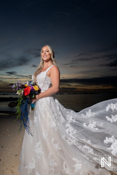 Bride in elegant dress poses by the beach at Sunscape Curacao Resort during a stunning sunset wedding celebration