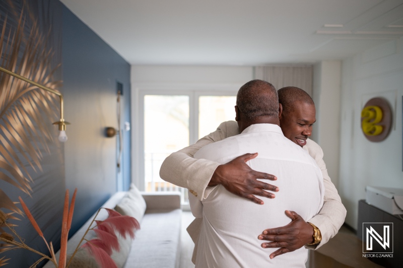 Emotional moment shared between groom and father before wedding ceremony at Renaissance Wind Creek Curacao Resort during sunset