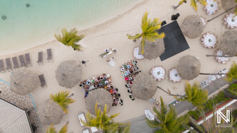 Beautiful sunset wedding ceremony at Renaissance Wind Creek Curacao Resort with guests gathered on the beach