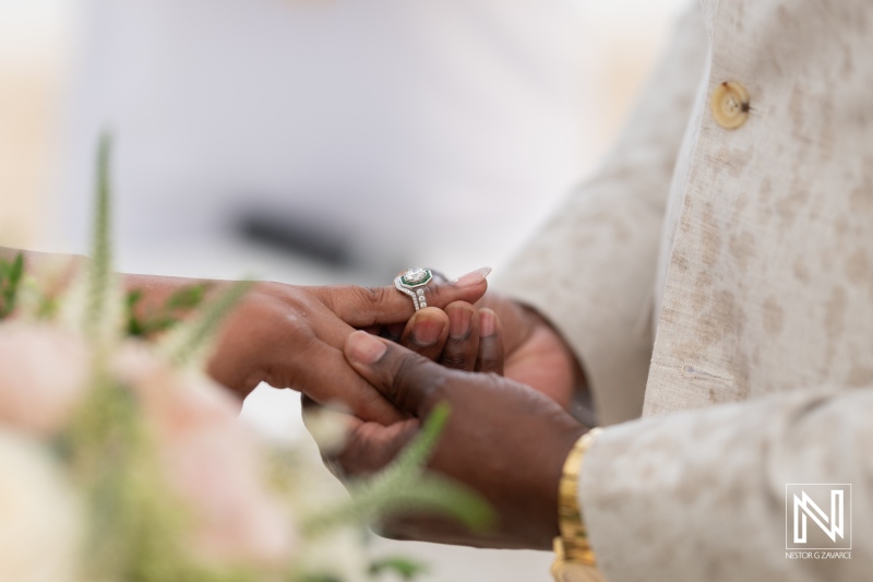 Couple exchanges wedding rings during sunset ceremony at Renaissance Wind Creek Curacao Resort against a picturesque backdrop