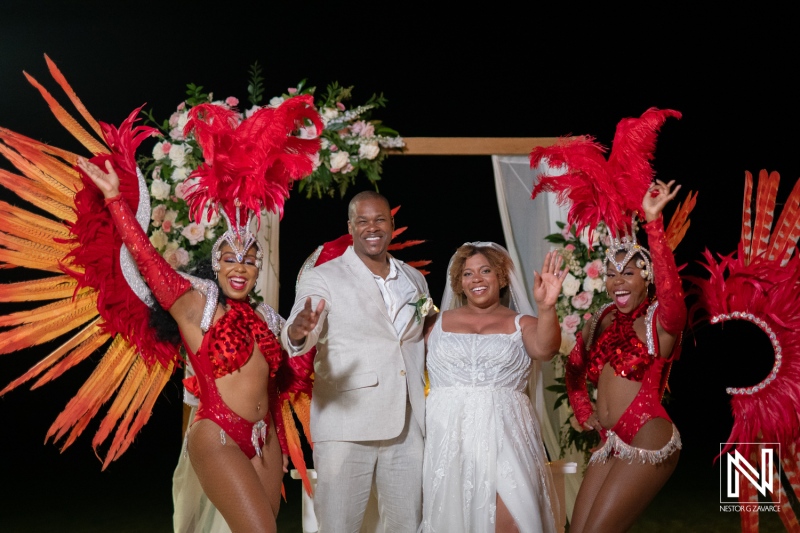 Couple celebrates their wedding with vibrant dancers at sunset in Curacao's Renaissance Wind Creek Resort