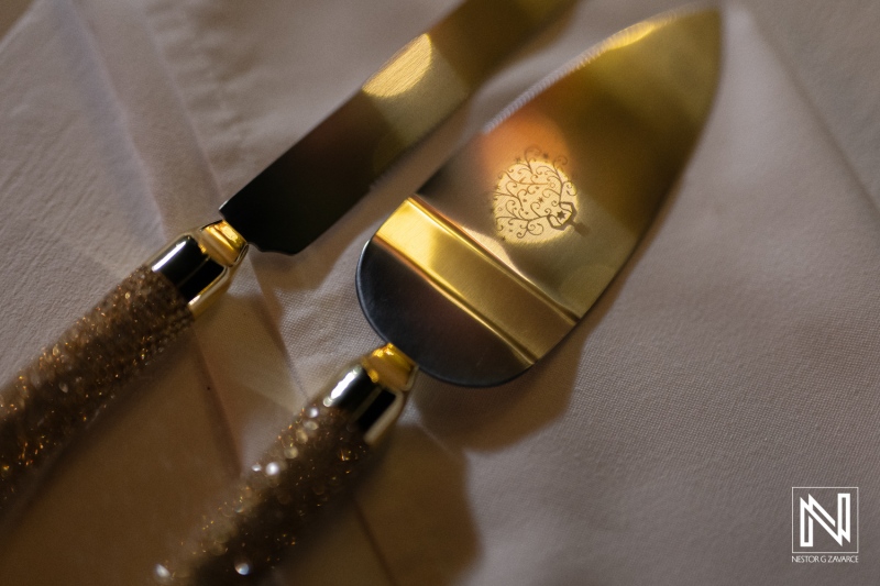 Elegant wedding cake knife set displayed at sunset wedding in Curacao's picturesque Renaissance Wind Creek resort