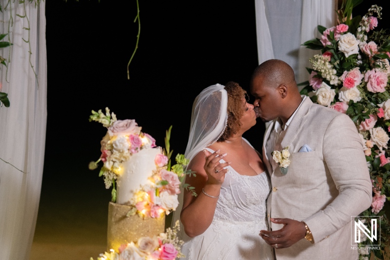 Couple shares a romantic kiss during their sunset wedding ceremony at Renaissance Wind Creek Curacao Resort