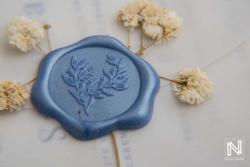 Elegant wedding details featuring blue wax seal and dried flowers at Playa Hunku in Curacao