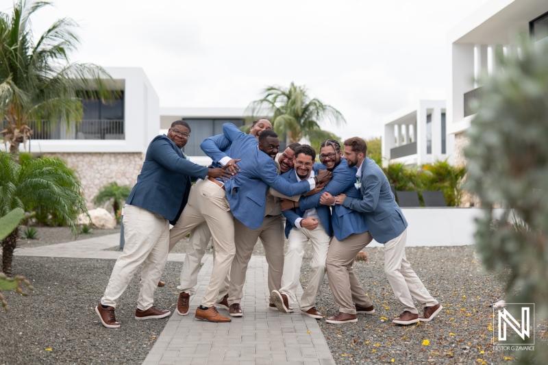 Joyful group of groomsmen celebrating together at Playa Hunku in Curacao during wedding preparations