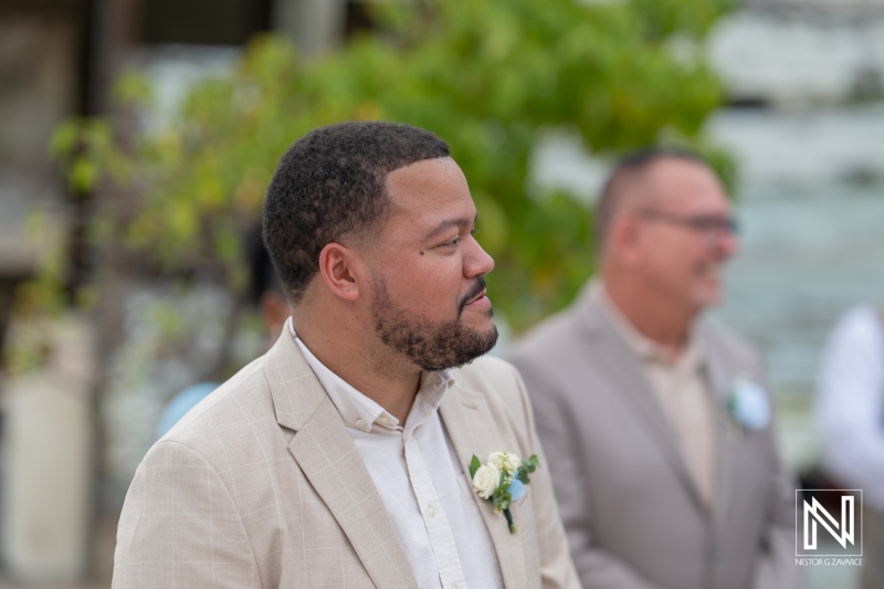 Groom smiling and awaiting his bride during a beautiful wedding ceremony at Playa Hunku, Curacao in a serene and scenic setting