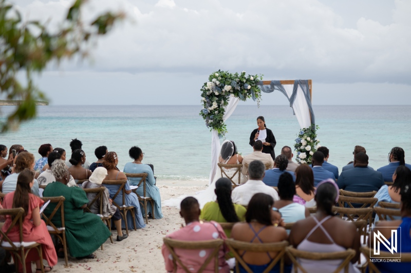 Romantic wedding ceremony at Playa Hunku, Curacao with guests gathered by the serene beach backdrop