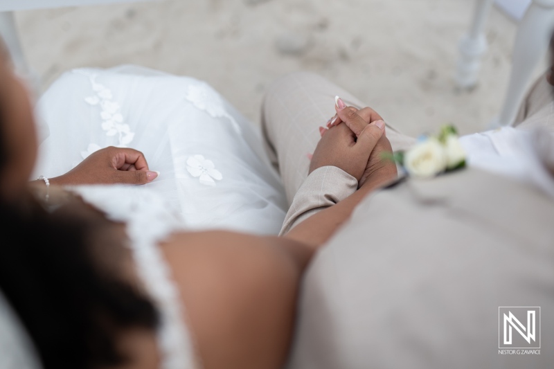 Celebration of love during a wedding ceremony at Playa Hunku in Curacao featuring tender handholding between the couple