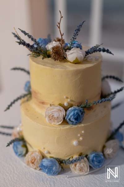 Elegant wedding cake adorned with delicate flowers at Playa Hunku in Curacao during a beautiful beach ceremony