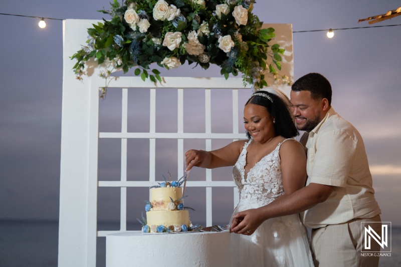 Couple celebrates their love with a beautiful wedding ceremony at Playa Hunku, Curacao during sunset with a stunning cake-cutting moment