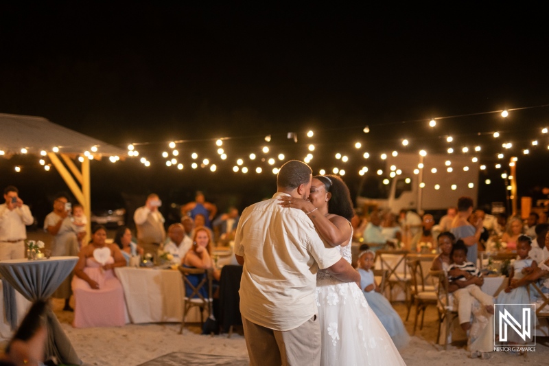 Couple shares first dance during romantic wedding celebration at Playa Hunku in Curacao under enchanting string lights