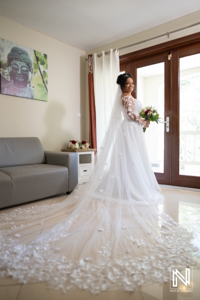 Stunning bride in flowing gown preparing for wedding at Acoya Curacao Resort with beautiful floral bouquet and elegant decor