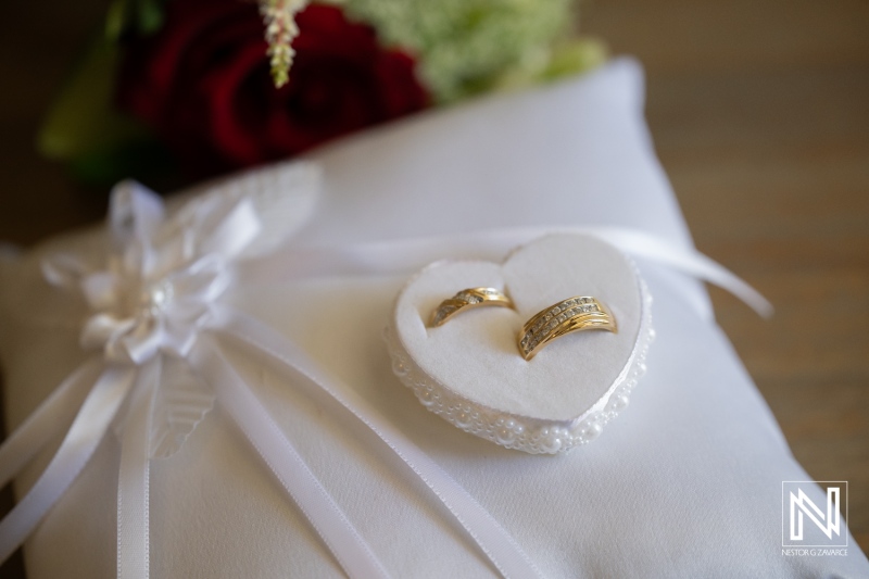 Wedding rings displayed on a heart-shaped pillow at a Curacao wedding ceremony at Acoya Resort
