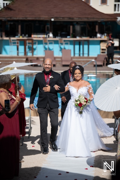 Wedding ceremony at Acoya Curacao Resort with a beautiful couple and guests enjoying a sunny day by the pool