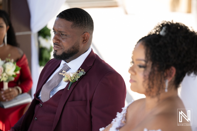 Couple shares intimate moment during wedding ceremony at Acoya Curacao Resort with family and friends present