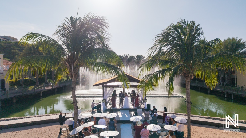 Wedding ceremony under the sun at Acoya Curacao Resort with guests gathered by the fountain