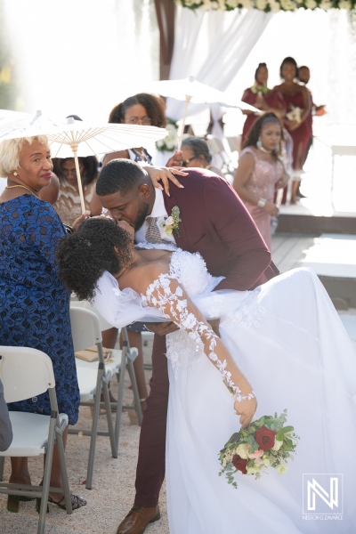 Beautiful wedding ceremony at Acoya Curacao Resort with heartfelt kiss and joyful guests celebrating love and unity