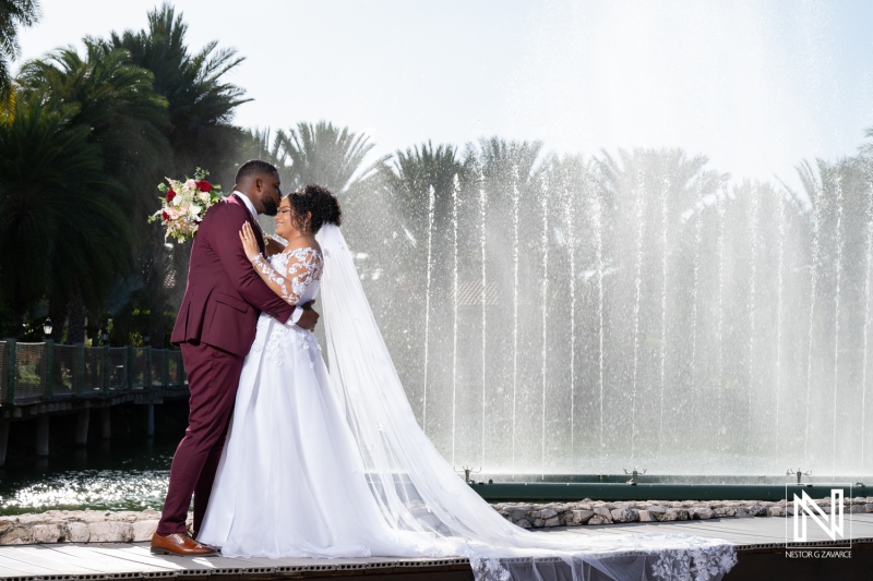Beautiful wedding celebration at Acoya Curacao Resort with couple embracing near fountain