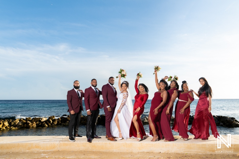 Beautiful wedding celebration at Acoya Curacao Resort with a joyful bridal party by the sea