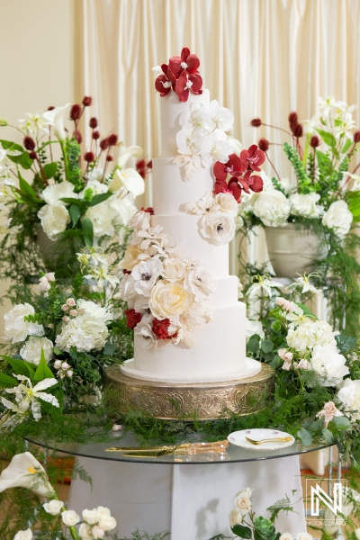 Elegant wedding cake surrounded by floral arrangements at Acoya Curacao Resort reception