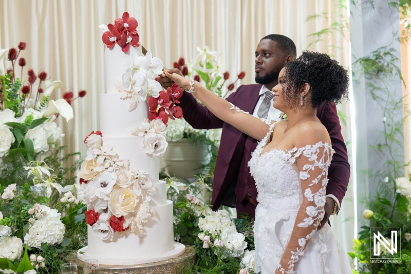 Couple shares a sweet moment while cutting their wedding cake at Acoya Curacao Resort reception