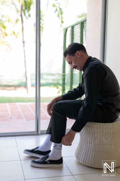 Groom prepares for a Halloween wedding at Sunscape Curaçao Resort with stylish socks and shoes