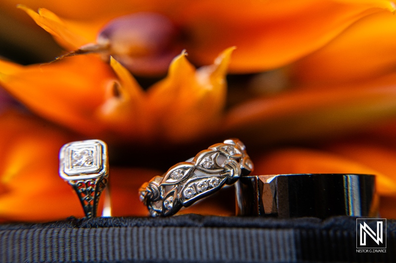 Wedding rings displayed beautifully against a backdrop of vibrant orange flowers in Curacao during a Halloween celebration at Sunscape Curaçao Resort