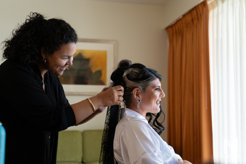 Bride getting ready for a Halloween-themed wedding at Sunscape Curacao Resort with hairstylist