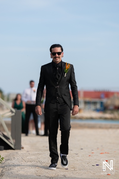 Groom walking towards the beach for a wedding ceremony at Sunscape Curacao Resort during a vibrant Halloween celebration