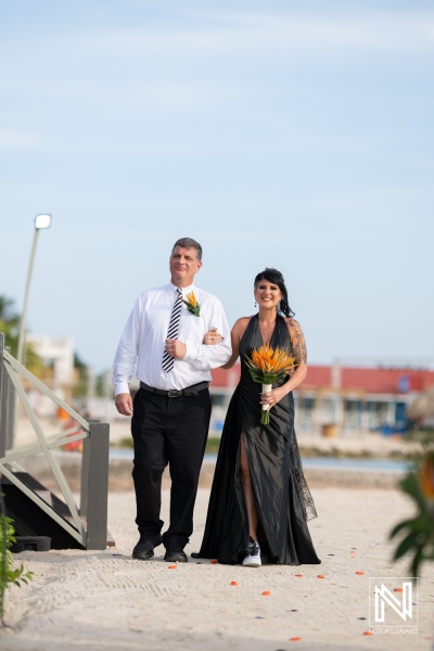 Couple walks down sandy path at wedding ceremony in Sunscape Curacao Resort during Halloween celebration