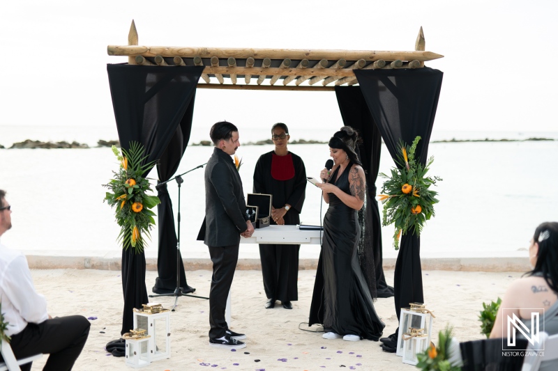 Couple exchanges vows during a Halloween-themed wedding ceremony at Sunscape Curaçao Resort by the beach