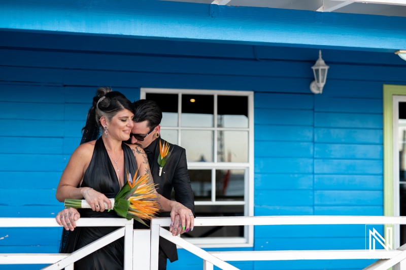 Couple celebrating their wedding at Sunscape Curacao Resort during Halloween with vibrant floral accents and a striking blue background