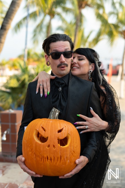 Couple celebrating Halloween wedding at Sunscape Curacao Resort with carved pumpkin