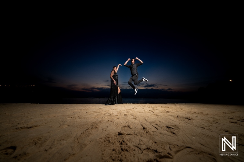 Couple celebrates Halloween wedding on the beach at Sunscape Curacao Resort during sunset with a joyful jump