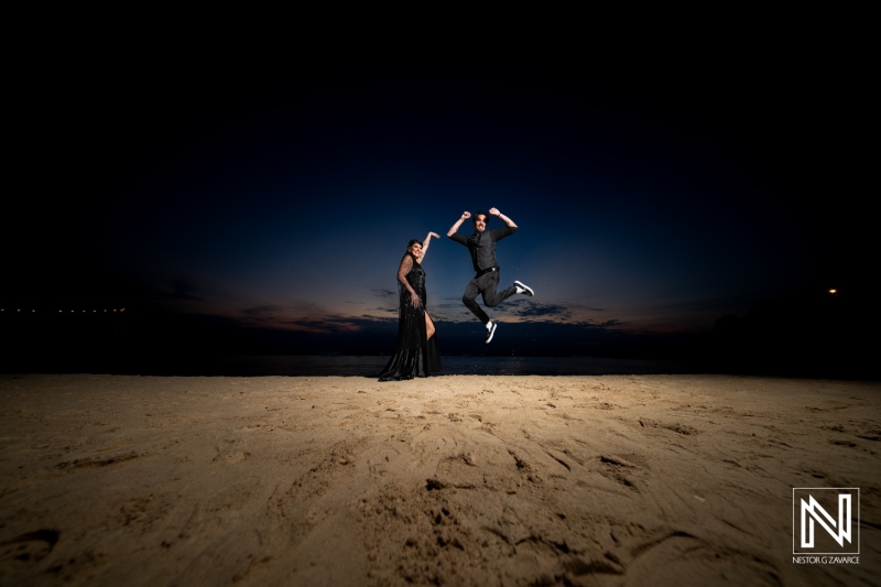 Couple celebrates Halloween wedding on the beach at Sunscape Curacao Resort during sunset with a joyful jump