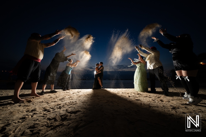 Couple shares a magical moment while surrounded by family and friends at a Halloween wedding on the beach in Curacao