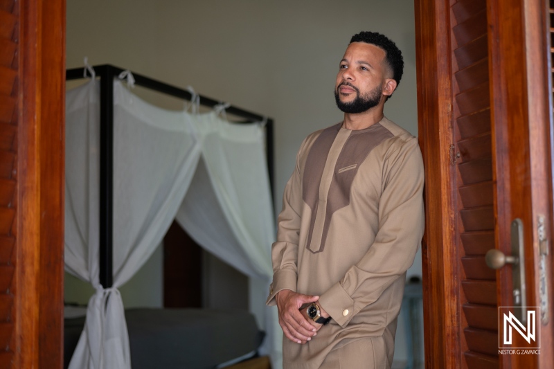 A Man in Traditional Attire Stands Confidently at the Doorway of a Decorated Room, Capturing a Moment of Contemplation and Elegance During an Afternoon