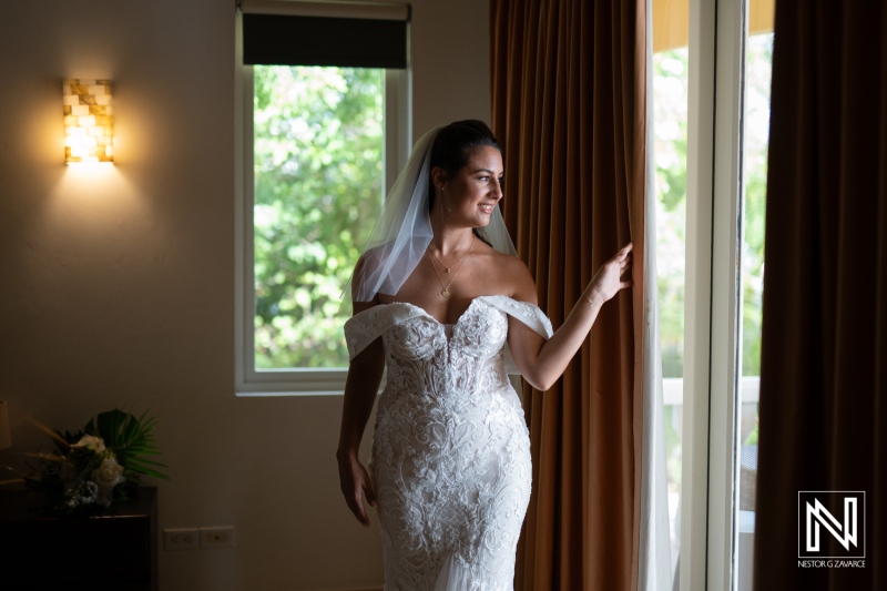 A Bride in an Elegant Wedding Dress Gazes out of a Window, Smiling Softly in a Sunlit Room, Preparing for Her Special Day During a Beautiful Morning