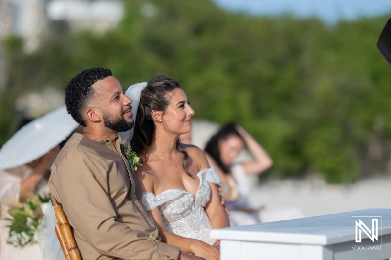 A Joyful Couple Enjoying Their Wedding Ceremony at a Beautiful Outdoor Location Under a Clear Blue Sky, Surrounded by Greenery and Close Friends