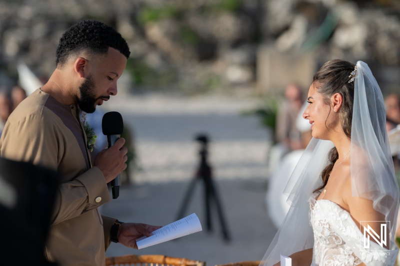 A Beautiful Couple Exchanges Heartfelt Vows During a Beach Wedding Ceremony Under the Warm Sun, Surrounded by Friends and Family