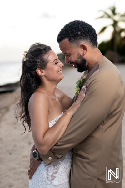 Couple Joyfully Embracing on a Sandy Beach at Sunset, Surrounded by Palm Trees and Ocean Waves, Celebrating Their Love During an Intimate Wedding Ceremony