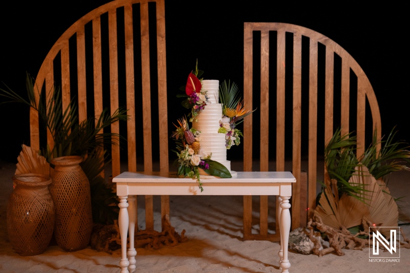 Elegant Wedding Cake Display With Lush Floral Arrangements in a Beautifully Decorated Outdoor Setting at Night