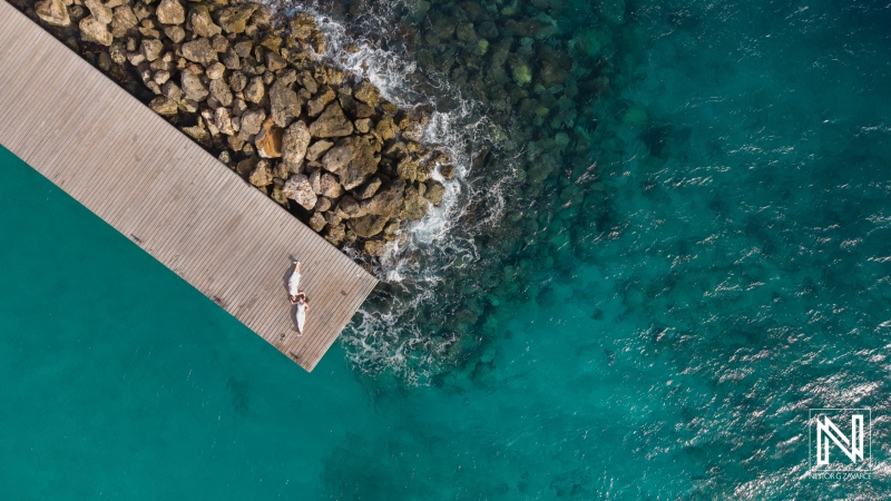 LGBT couples sharing a romantic moment during wedding photoshoot at sunset over scenic Willemstad in Curacao
