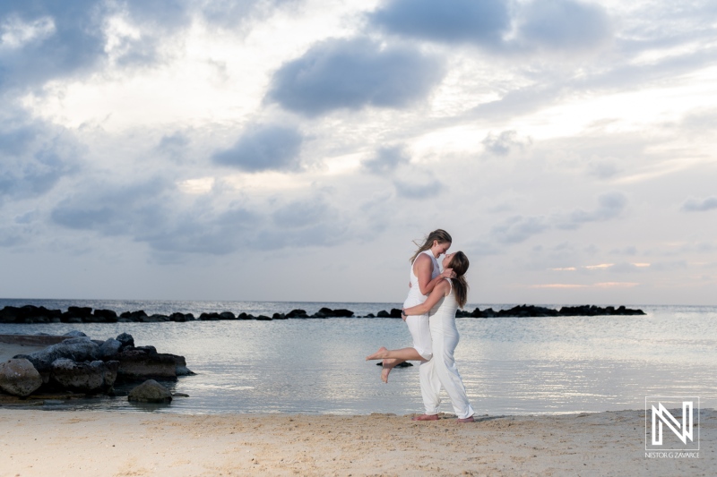 LGBT wedding photoshoot captures joyful moments during sunset in stunning Willemstad, Curacao, on a sandy beach by the tranquil sea