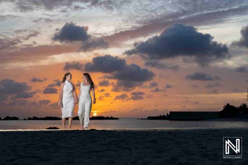 LGBT couple enjoys a romantic sunset wedding photoshoot on the beach in Willemstad, Curacao, capturing love and joy against a picturesque backdrop